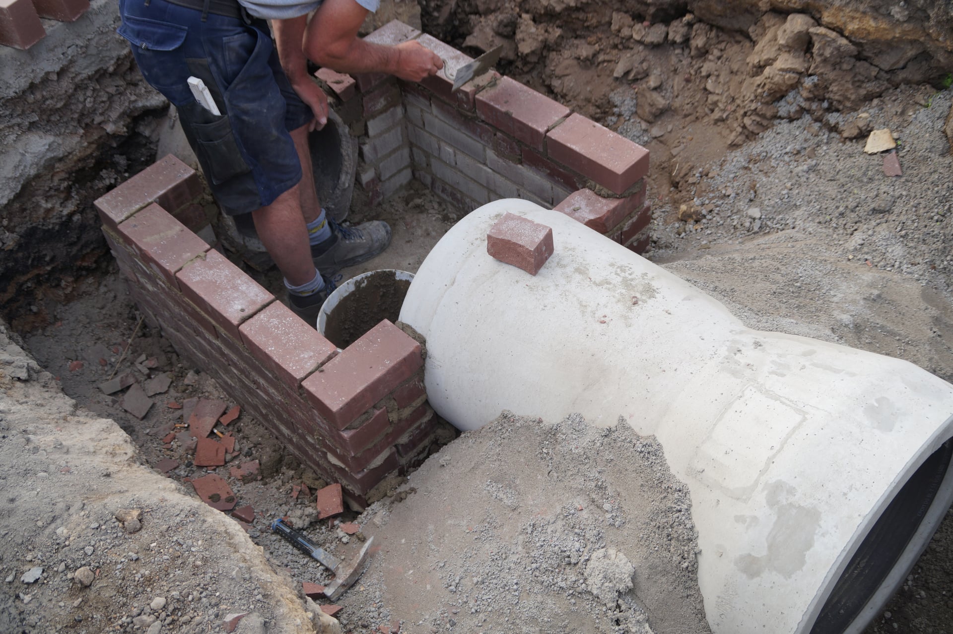 Originalfoto: Arbeiten an einem gemauerten Schacht im Tiefbau